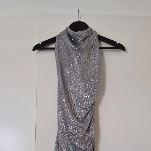 Silver glittrig långklänning från Bik Bok - Säljer en silverfärgad långklänning från Bik Bok täckt av glittriga paljetter.
