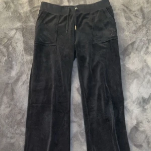Svarta Juicy Couture Byxor - Svarta Juicy Couture Byxor. Storlek M, Lite slitna, saknas en metall del från snöret på framsidan och det saknas en knapp på båda fickorna på baksidan, men fortfarande väldigt bekväma och mysiga. 