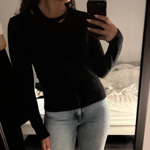 Svart kofta från SHEIN  - Säljer en klassisk svart kofta från SHEIN med knappar framtill. Perfekt för lager-på-lager och passar till många olika outfits. Koftan har långa ärmar och en enkel design.