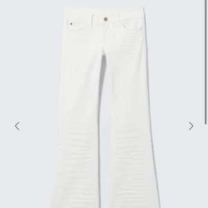 Vita bootcut jeans från Cheap Monday - Slutaålda vita bootcut jeans från Cheap Monday med klassisk femficksdesign och snygg logga bak i midjan. Jeansen har utsvängda ben och är tillverkade i bomull. Perfekta för dig som vill sticka ut med en clean look.använda typ 3 gånger STORLEK 26/32