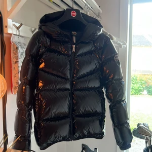 Svart glansig jacka från Colmar - Säljer en superfin svart och glansig jacka från Colmar. Ny skick då den bara är använd en säsong. Storlek 14 dvs passar någon som är 160cm-167cm lång. Galgen medföljer vid köp. Köpt för 4600kr. Passar perfekt till hösten & vintern! Skriv privat för fler bilder eller funderingar💕