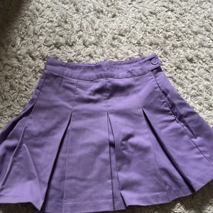 Ljuslila plisserad kortkjol - Superfin ljuslila kortkjol. Från HM, har klippt hål för att passa en mindre midja, pris går att diskuteras, används många gånger