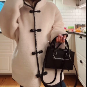 Beige teddyjacka med svarta detaljer - Säljer en oversized beige teddyjacka med svarta knappar!! Från H&M💕