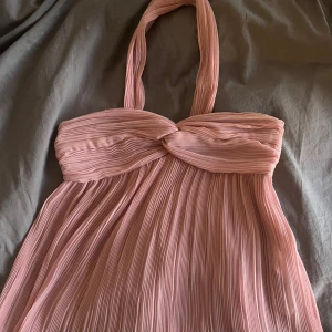 Rosa topp Zara - Supersöt plisserad rosa topp från Zara med twistad healterneck. Lätt och luftig, passar perfekt till varma dagar eller speciella tillfällen. Säljer eftersom den är för liten💕