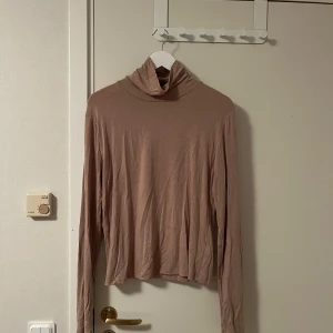 Beige polotröja med lång ärm från bikbok - Säljer en tunn och mjuk beige polotröja med lång ärm. Tröjan har en klassisk polokrage och är tillverkad i ett lätt material som känns skönt mot huden. Perfekt att styla lager på lager under kyligare dagar. Katt finns i hemmet
