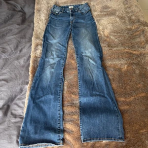 Blå bootcut jeans från Lindex - Högmidjade blåa jeans från Lindex med klassisk bootcut-passform. Osäker på storlek men skulle gissa på 34 men stretchiga. 