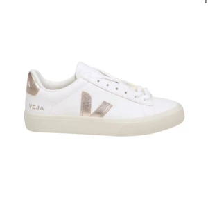 Vita sneakers från Veja med guldiga detaljer - Stilrena vita sneakers från Veja med metallicguld detaljer på sidan och hälen. Klassisk låg modell med snörning och platt sula. Perfekta för dig som gillar minimalistisk design med en touch av lyx.