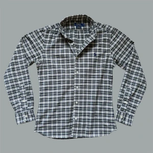 Ralph Lauren Skjorta - Säljer nu denna sjukt snygga Ralph Lauren button-down skjortan! Skick 9/10, den är uppsydd så kan hända att den påsar sig i ryggen på vissa. Inget som man dock tänker på. Mått: bröstvidd: 50cm, armlängd fr axel: 65cm längd fr axel: 61cm. Om du undrar något är det bara att fråga! OBS ser grå ut på första två bilderna men den riktiga färgen syns i de andra bilderna