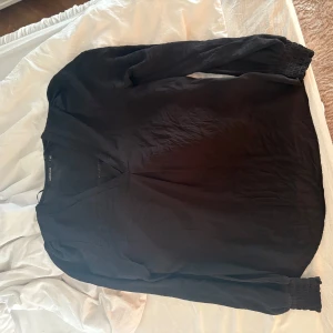 Svart blus med v-ringning  - Snygg svart blus  med v-ringad hals och långa ärmar. 
