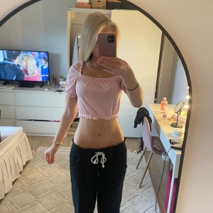 Ljusrosa croppad topp från H&M Divided - Supersöt ljusrosa croppad topp från H&M Divided med puffärmar och smockad resår i både midja och halsringning. Toppen kan bäras både på axlarna och offshoulder. Perfekt för en somrig look och lätt att matcha med jeans eller kjol.