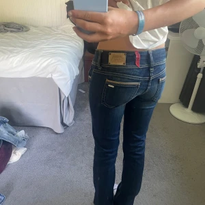 Mörkblå cerises låg midja - Säljer ett par mörkblå jeans från cerises med låg midja och raka ben. Jeansen har snygga, dubbla knappar i midjan och coola detaljer på fickorna. 