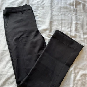 Svarta kostymbyxor från Stories, stl 34 - Klassiska svarta kostymbyxor från Stories i storlek 34. Snygga och stilrena som funkar till många olika outfits! Materialet känns mjukt och har en lätt stretch. Har sytt upp de, men superenkelt o fixa tillbaka💖