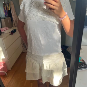 Topp med broderier  - Supersöt vit topp med broderier. perfekt för varma dagar. Materialet känns lätt och skönt mot huden. 