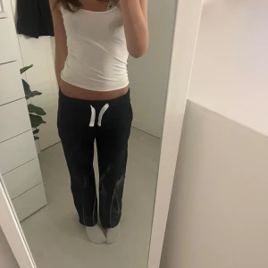 Marin blå  mjukisbyxor med snörning från russemerch - Svarta mjukisbyxor med vit snörning i midjan och raka ben. Byxorna har en avslappnad passform och är tillverkade i mjukt bomullsmaterial. Perfekta för chill dagar eller när du vill vara bekväm. Klassisk look med fickor på sidorna. Domma har också en liten fläck titta sista bilden men inget som stört mig säljer domma för dom blivit för korta💞💞