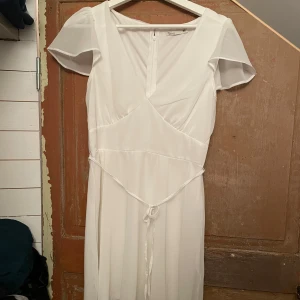 Vit kortklänning med v-ringning och knytband - Endast använd 1 gång💕