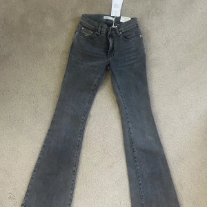 Grå bootcut jeans från Perfect Jeans - Snygga grå bootcut jeans från Gina tricot med låg midja. Jeansen har klassisk femficksdesign, dragkedja och knapp framtill. Perfekta för dig som gillar en tidlös och stilren look.