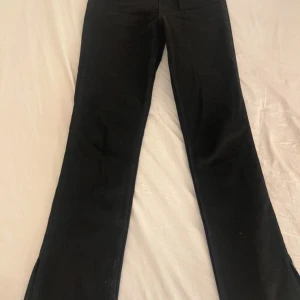 Svarta jeans med slits  - Slits på utsidan av byxorna, ser helt oanvända ut.