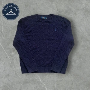 Mörkblå stickad tröja från Polo Ralph Lauren - Säljer en mörkblå stickad tröja från Polo Ralph Lauren med klassiskt kabelstickat mönster och rund halsringning. Tröjan har långa ärmar och en liten broderad logga på bröstet. Tröjan är storlek M men är lite mindre i storleken så passar S 🤩Perfekt för en stilren och snygg look.