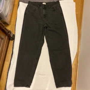 Svarta jeansbyxor från YOURTURN 34/34 - Säljer ett par svarta jeansbyxor från YOURTURN med klassisk femficksdesign och raka ben. Byxorna har normal passform och stängs med knapp och dragkedja. Perfekta till många olika outfits.