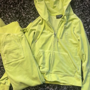 Gröna mjukisbyxor från Juicy Couture - Säljer ett par ljusgröna mjukisbyxor från Juicy Couture med dragsko i midjan och fickor både fram och bak. Byxorna har en klassisk Juicy Couture-logga broderad framtill och är tillverkade i mjuk velour.
