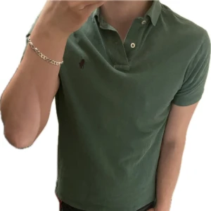 Grön pikétröja från Polo Ralph Lauren - Grön pikétröja från Polo Ralph Lauren i modellen Custom Slim Fit. 