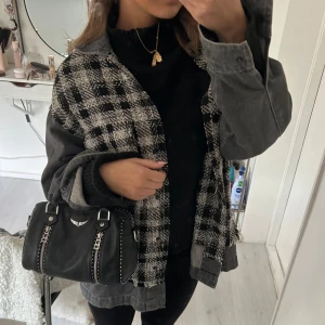 Svart och vit rutig jeansjacka - Trendig svart och vit rutig jeansjacka med oversized passform. Jackan har långa ärmar i grå denim. Aldrig använd