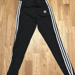 Svarta Adidas leggings  - Observera ett mini hål på högra ben på sista bilden. Annars helt bra skick!