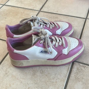 Vita och rosa sneakers från Autry  - Säljer ett par snygga sneakers från Autry i vitt och rosa med klassisk design. Nypris: 1700kr i läder 