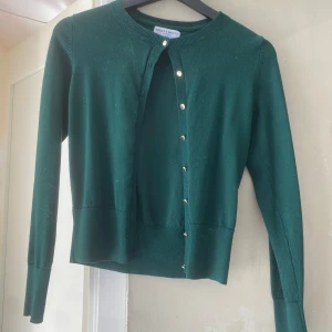 Grön kofta från Holly&Whyte - Säljer denna gröna kofta köpt från Lindex. Köpte för cirka 1 år sedan men använder inte längre. Nypris: cirka 350kr