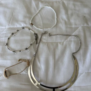 3 armband och 1 halsband i olika stilar - Säljer ett set med fyra smycken: ett guldigt armband med snäcka, ett pärlarmband med vita och silverfärgade pärlor, ett enkelt vitt pärlarmband och ett brett silvrigt halsband. Perfekt för att mixa och matcha till olika looks. 65 kr för alla 4 