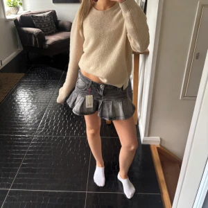 Grå jeanskjol med volange  - Säljer denna gråa jeanskjol med volang som är lågmidjad. Den är helt ny med lappen kvar!