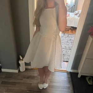 Vit klänning öppen rygg - Superfin vit klänning med strukturerat tyg, rund hals och markerad midja. Klänningen har en öppen rygg med knytband som man kan knyta till en rosett. Perfekt för student, skolavslutning🤍🌸 använd 1 gång, pris kan diskuteras 
