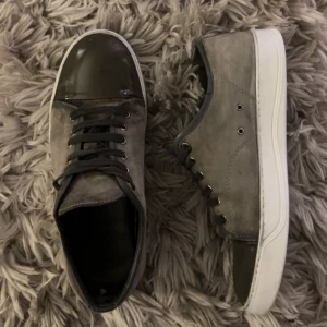 Lanvin skor  - Säljer ett par gröna/Grå skor från Lanvin i bra skick. Skorna har en snygg kombination av skinn och mocka med en glansig tå och snörning. Sulan är i en ljusare beige färg som ger en cool kontrast. Perfekta för både vardag och fest! Skriv för fler frågor och bilder. Pris kan diskuteras vid snabb affär!! Skickas inom en dag🚚📦