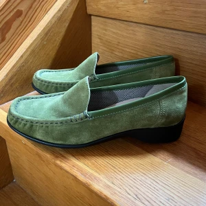 Gröna mockaloafers - Säljer ett par stilrena gröna loafers i mocka med klassisk design och låg klack. 