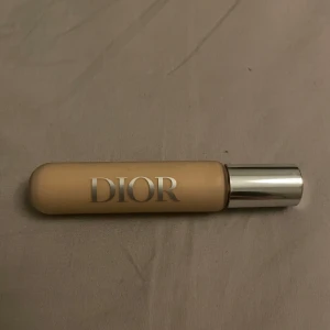 Dior Backstage Concealer 2N - Dior Backstage Concealer i nyansen 2N. Flytande concealer med silvrig kork och elegant design. Perfekt för att täcka ojämnheter och ge en naturlig finish. Kommer i en smidig tub med applikator.