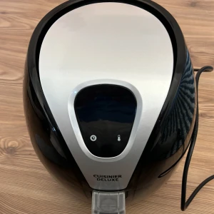 Cuisinier Deluxe airfryer - Säljer en svart och silver airfryer från Cuisinier Deluxe. Den har digital panel framtill och en rymlig korg med non-stick beläggning. Perfekt för att laga mat snabbt och enkelt utan olja. Modern design och enkel att använda.