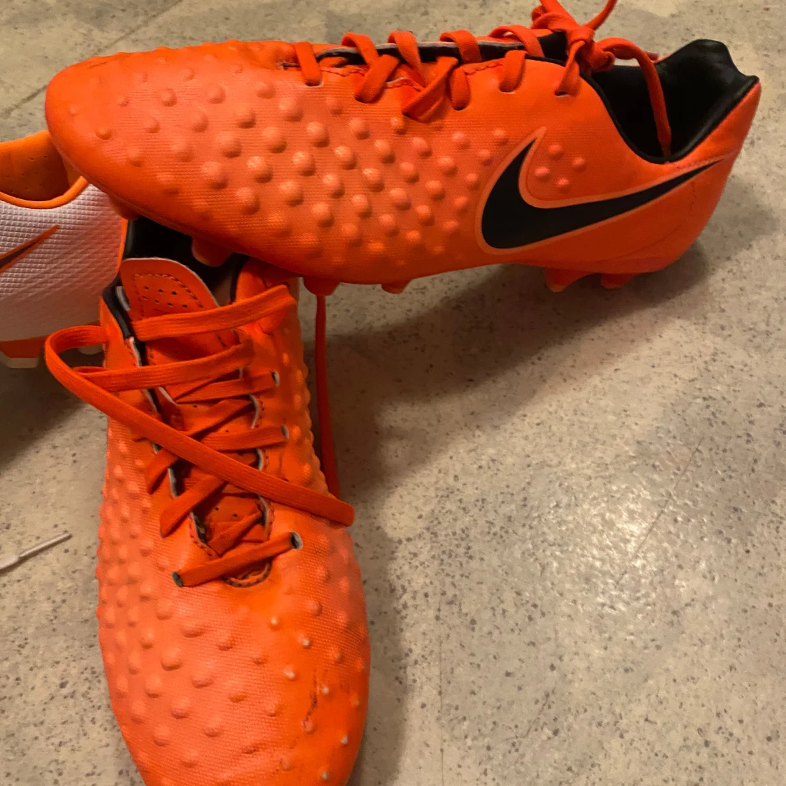 Orangea Nike fotbollsskor med svarta detaljer