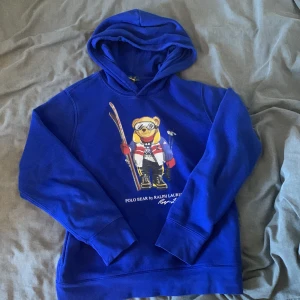 Blå polo bear tröja - Säljer en snygg blå tröja som passar till sommaren. Inga brister förutom att björnen har tappat lite tryck. Tröjan är köpt på kidsbrandstore i storlek 14-16 men har blivit något mindre. Hör av dig vid minsta fundering eller för fler bilder!