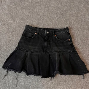 Svart jeanskjol med volang från Monki - Säljer en svart jeanskjol från Monki med volangdetaljer. Kjolen är använd 1 gång då jag provat den!. 💘💘 skriv vid frågor