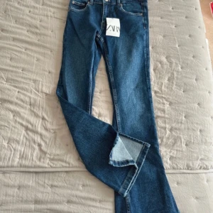 ZARA Flare Jeans – Strl 11-12 år (152 cm) - Säljer ett par superfina bootcut jeans från Zara i modellen “Flare Pant”. De är aldrig använda, endast provade – prislappen sitter fortfarande kvar (nypris 279 kr). Jeansen är tillverkade i denim med en autentisk mörkblå tvätt och har en klassisk femficksdesign. De har en lätt utsvängd passform nertill och en justerbar midja med knappresår på insidan för perfekt passform i midjan!