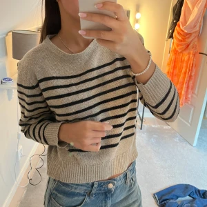 Beige och svart randig stickad tröja - Beige stickad tröja med svarta ränder. Den är lite noppig men går fortfarande att använda. Storleken är xs/s
