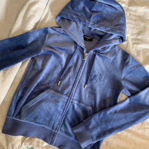 Juicy couture zip up hoodie - I storlek M och är nästan som ny. Har inga defekter alls och använt 2 gånger endast. Tvättat en gång och är fortfarande lika fluffig o mjuk inte alls sträv. Säljer billigt då jag vill bli av med den.
