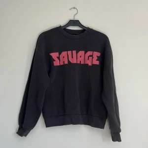 Svart sweatshirt med röd SAVAGE-tryck - Cool svart sweatshirt med stort röd SAVAGE-tryck på bröstet.(trycket har slitits lite)❤️‍🔥