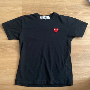 Svart t-shirt Comme des Garçons Play - Svart t-shirt från Comme des Garçons Play med klassisk rund hals och korta ärmar. Pris kan diskuteras 