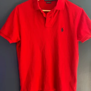 Röd Polo Ralph Lauren t-shirt slim fit - Snygg röd Piké  från Polo Ralph Lauren i slim fit-modell. Piken är i str S. Använd ett fåtal gånger!
