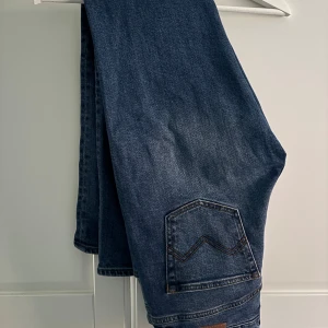 Morris blå jeans, storlek 30/32 - Snygga mörkblå jeans från Morris i klassisk straight fit. Jeansen har fem fickor, orangea sömmar och en cool detalj på bakfickan. Materialet är slitstarkt jeans och passformen är normal. De är använda bara ett fåtal ggr , då menar jag kanske 3 gånger. Nypris ligger nån stans vid 1500 kr. 