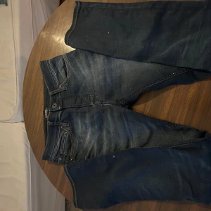 Mörkblå jeans från Jack & Jones - Snygga mörkblå jeans från Jack & Jones med klassisk femficksdesign och kontrastsömmar. Modellen har rak passform och är tillverkad i slitstarkt denim med lätt tvättade detaljer. Perfekt för dig som gillar en enkel och stilren look.