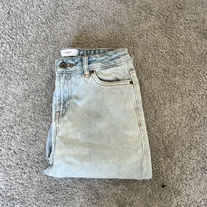 Ljusblå jeanse från grunt - Säljer ett par ljusblå jeans från Grunt. De har raka ben och en  klassisk femficksdesign. Jeansen är tillverkade i jeansmaterial och har en snygg, avslappnad passform som är perfekt för en chill stil. Använda 3-4 gånger.  Hör av er vid frågor👏