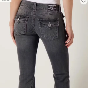 True Religion grå bootcut jeans - Snygga grå jeans från True Religion med bootcut passform och klassiska fickor med lock och silverknapp bak. Aldrig använda endast hunnit tvätta dom en gång