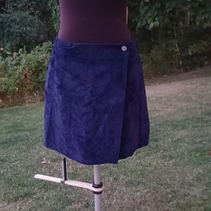 Mörkblå omlottkjol - Mörkblå omlottkjol från Lemon i sammet eller sammetliknande material. Använd men i fint skick💙🪼🦋 Jag är s/m och kan ha den men skulle säga att den passar L också. Det är bara att skriva om man har frågor!😊💖